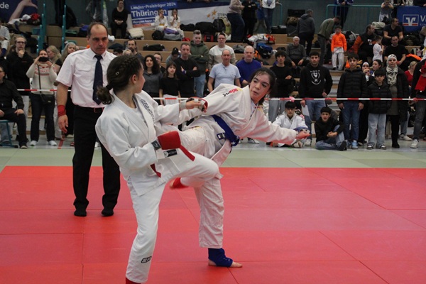 Tuba Yusufi (blau) trifft mit einem Fußstoß